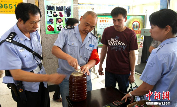 資料圖：7月29日，公安民警和安保人員正在克拉瑪依客運站進站口嚴查進站旅客行李和違禁物品。 周建玲 攝