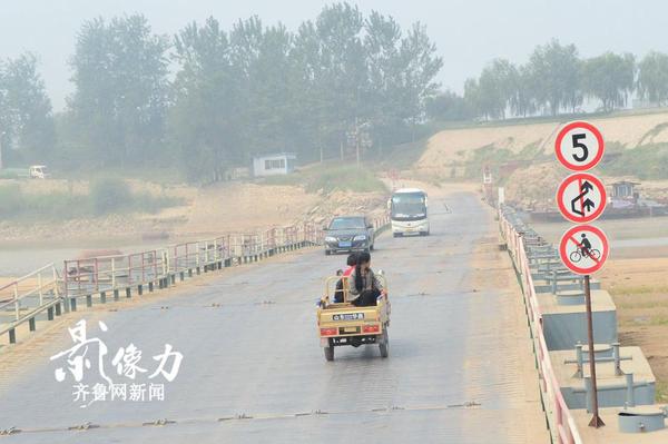 濟南北店子黃河浮橋兩側也設有提示牌，禁止自行車上橋，一輛三輪車慢慢駛向對岸。（圖文 李瑞平）