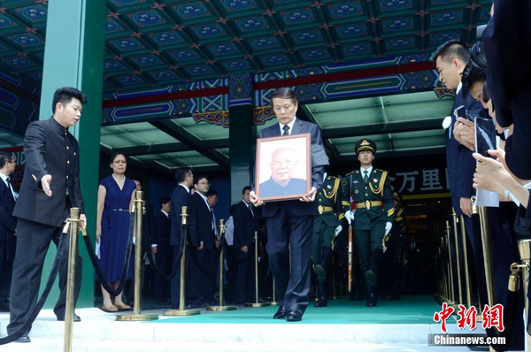 7月22日，萬里遺體在北京火化，社會各界人士前往八寶山殯儀館進(jìn)行悼念。圖為萬里兒子萬伯翱手捧遺像步出。 中新社發(fā) 盛佳鵬 攝