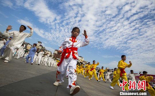 少年太極拳愛(ài)好者在江西都昌縣一廣場(chǎng)上表演太極拳?！「到ū蟆z