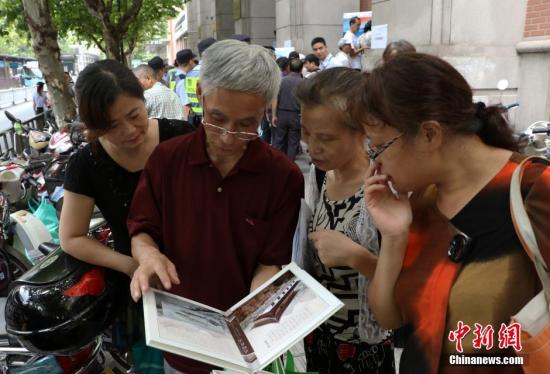 資料圖：幾位杭州市民欣賞已買到的“G20杭州峰會(huì)明信片”。 中新社記者 王剛 攝