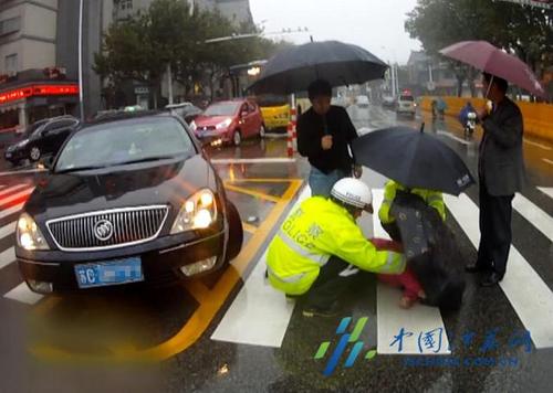 江蘇徐州女子雨中被撞倒地 民警為其撐傘遮雨