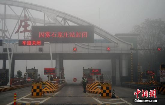 11月3日，受大霧影響，位于京港澳高速石家莊裕華路收費站高速入口已經(jīng)關閉，交警在入口處設置圍擋，并疏導過往車輛。該省氣象臺發(fā)布大霧橙色預警信號，保定、廊坊及以南大部分地區(qū)有能見度低于200米的濃霧。 中新社記者 翟羽佳 攝