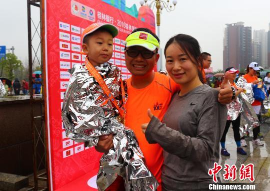 來自廣州的李強(qiáng)夫婦用兒童車，載著4歲的兒子，一家三口完成了在桂林舉行的半程馬拉松比賽?！W惠蘭 攝