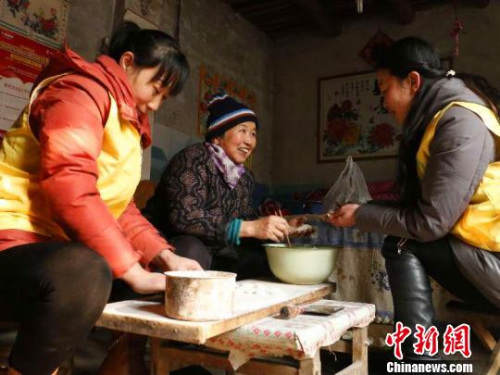 資料圖：除夕，巨鹿縣居家養(yǎng)老服務中心工作人員王勝晨、陳云彩和失獨老人張會群一起包餃子。　王丙強 攝