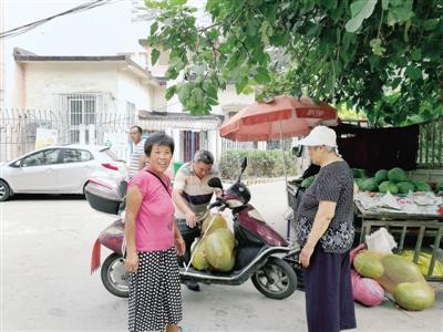 小區(qū)掛條幅歡迎瓜農來賣瓜 物業(yè)給瓜農端來紅燒肉