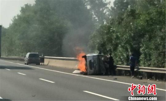 圖為：杭甬高速寧波段一輛面包車側翻后起火，好心人救一家7口?！『问Y勇 攝