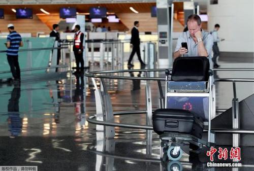 此前，阿聯(lián)酋航空、埃及航空等相繼暫停往返卡塔爾首都多哈的航班，沙特等國(guó)甚至禁止卡塔爾航空班機(jī)越過(guò)領(lǐng)空，令中東航空樞紐多哈的哈馬德國(guó)際機(jī)場(chǎng)陷入混亂。圖為一名游客在哈馬德國(guó)際機(jī)場(chǎng)看手機(jī)。