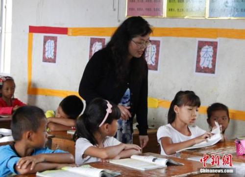 9月22日，在偏遠山區(qū)的廣西柳江縣穿山鎮(zhèn)六廟小學，幾間瓦房教室、宿舍，操場上3張乒乓球臺就是學生和老師的一切。48歲的韋鳳玲在給學生們上課，“下雨時，人在上課雨從頭頂落”，韋鳳玲這樣形容學校環(huán)境。2014年從老撾完成兩年支教任務的柳江縣第二中學教師韋鳳玲，又到該縣土博鎮(zhèn)、穿山鎮(zhèn)村級小學支教，被稱為支教“專業(yè)戶”。朱柳融 攝