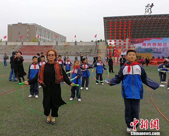 西班牙馬德里愛華中文學(xué)校校長黃小捷饒有興致地與學(xué)生進行跳繩比賽?！罱苡?攝