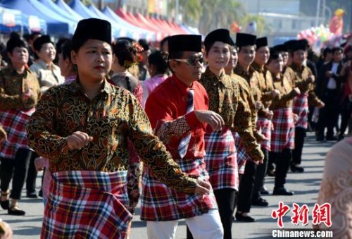 踩街隊伍在美食街上穿行表演，整個活動現(xiàn)場成為歌舞的海洋。　張金川　攝