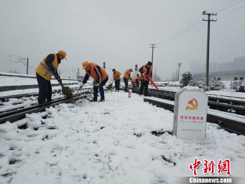 南京東車(chē)輛段貨車(chē)檢車(chē)員風(fēng)雪里按標(biāo)作業(yè)，堅(jiān)守崗位保障運(yùn)輸安全。（劉寅 攝）