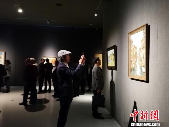 圖為，在“印象山東——俄羅斯油畫家寫生作品展”上，觀眾在喜歡的作品前駐足觀賞、拍照?！O宏瑗 攝