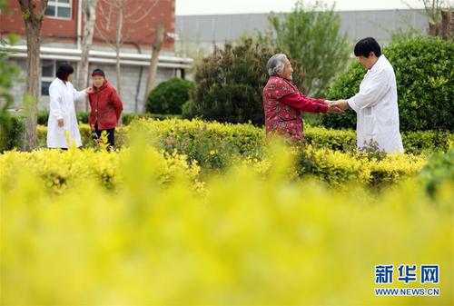 5月5日，在河北省衡水市桃城區(qū)一家養(yǎng)老康復(fù)醫(yī)療中心，護工在陪老人散步。新華社記者 牟宇 攝