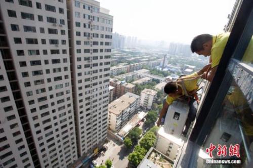 資料圖：在山西太原，空調(diào)安裝工程師頂著酷暑高溫，為市民安裝空調(diào)。<a target='_blank' href='http://www.chinanews.com/'>中新社</a>記者 張?jiān)?攝