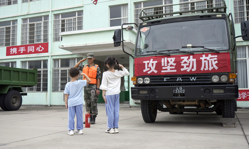 圖為在學(xué)校宿營點(diǎn)，小學(xué)生向抗洪官兵官兵敬禮表達(dá)謝意的畫面。（付少旋）