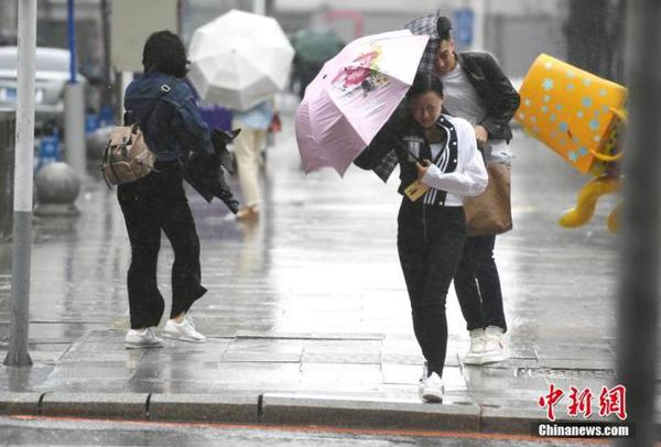 資料圖：市民頂風(fēng)冒雨出行。 中新社記者 張瑤 攝