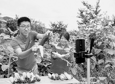 山西平順縣南坡村大學(xué)生王亞鵬（左）回村創(chuàng)業(yè)成為“新農(nóng)人”，圖為他正在直播銷售農(nóng)產(chǎn)品。新華社發(fā)